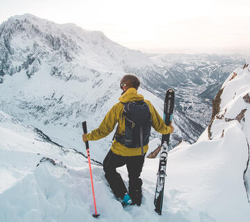 Skieur hors piste qui observe les montagnes enneigées