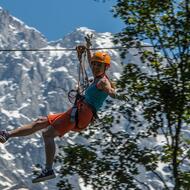 Femme glissant sur une tyrolienne en souriant